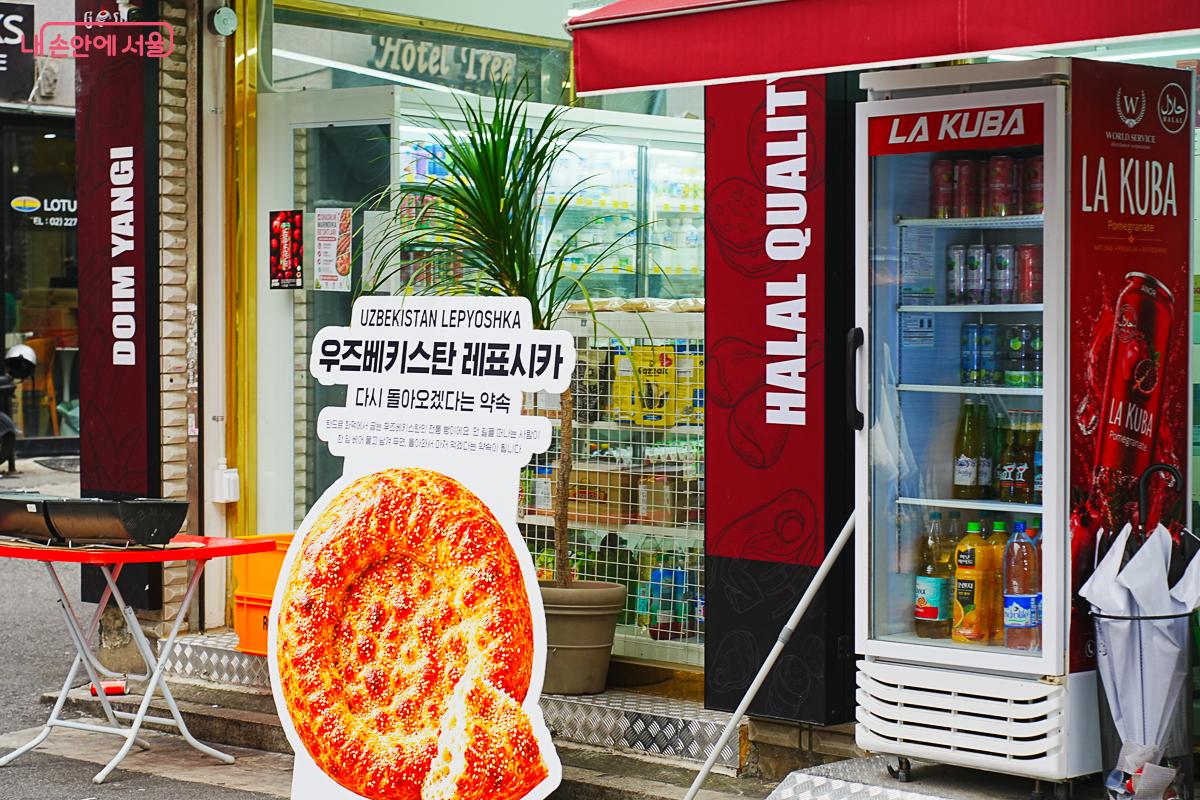 'UZBEKISTAN LEPYOSHKA 우즈베키스탄 레표시카'라고 적힌 빵 모양 조형물이 상점 앞에 세워져 있다.