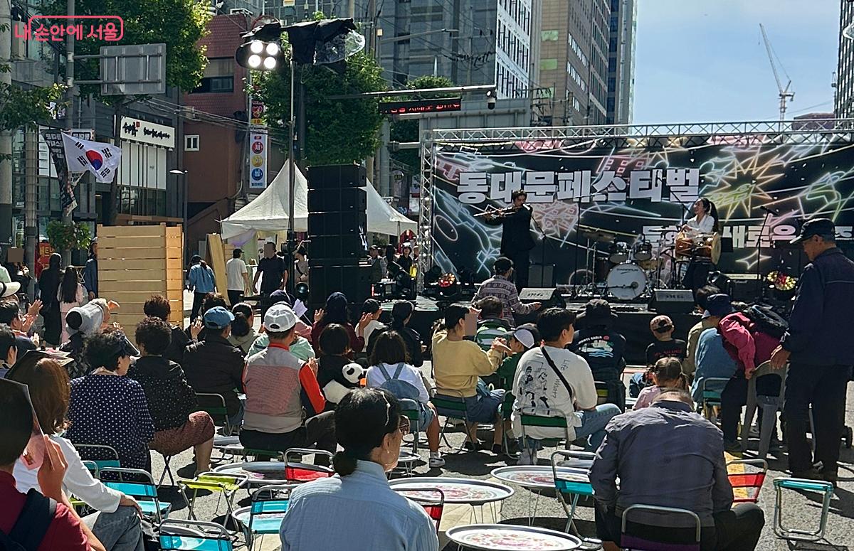 철제 밥상에 간이의자에서 즐기는 거리공연 모습 &copy;조성희