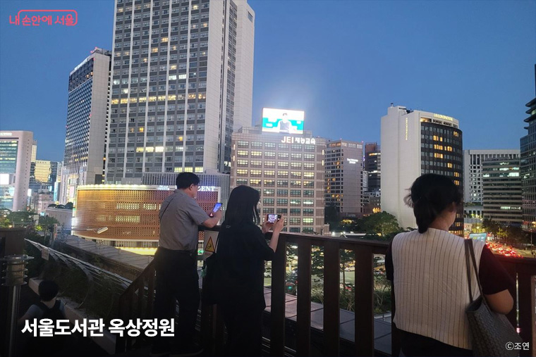 해 질 무렵 서울도서관 옥상정원 &lsquo;하늘뜰&rsquo;에서 시민들이 아경을 즐기고 있다. 