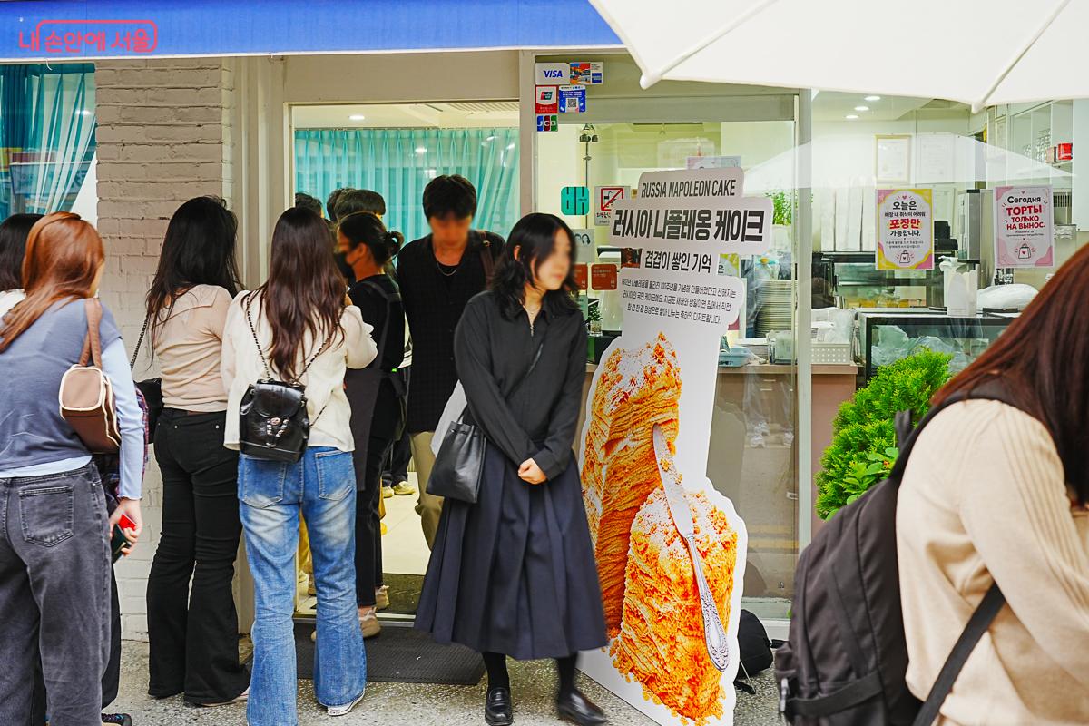 '러시아 나폴레옹케이크' 안내 문구가 붙은 가게 앞에서 시민들이 줄을 서 있다.
