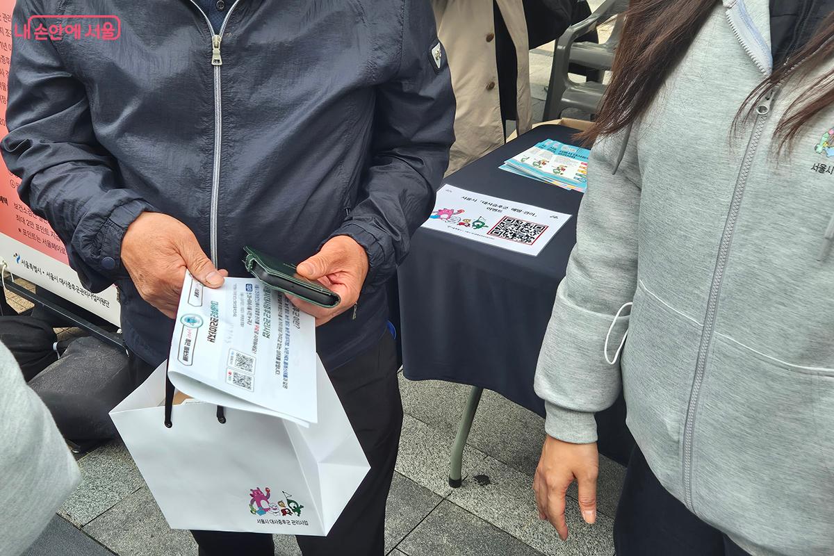 사은품으로 받은 건강 관리 키트를 들고 있는 참가자