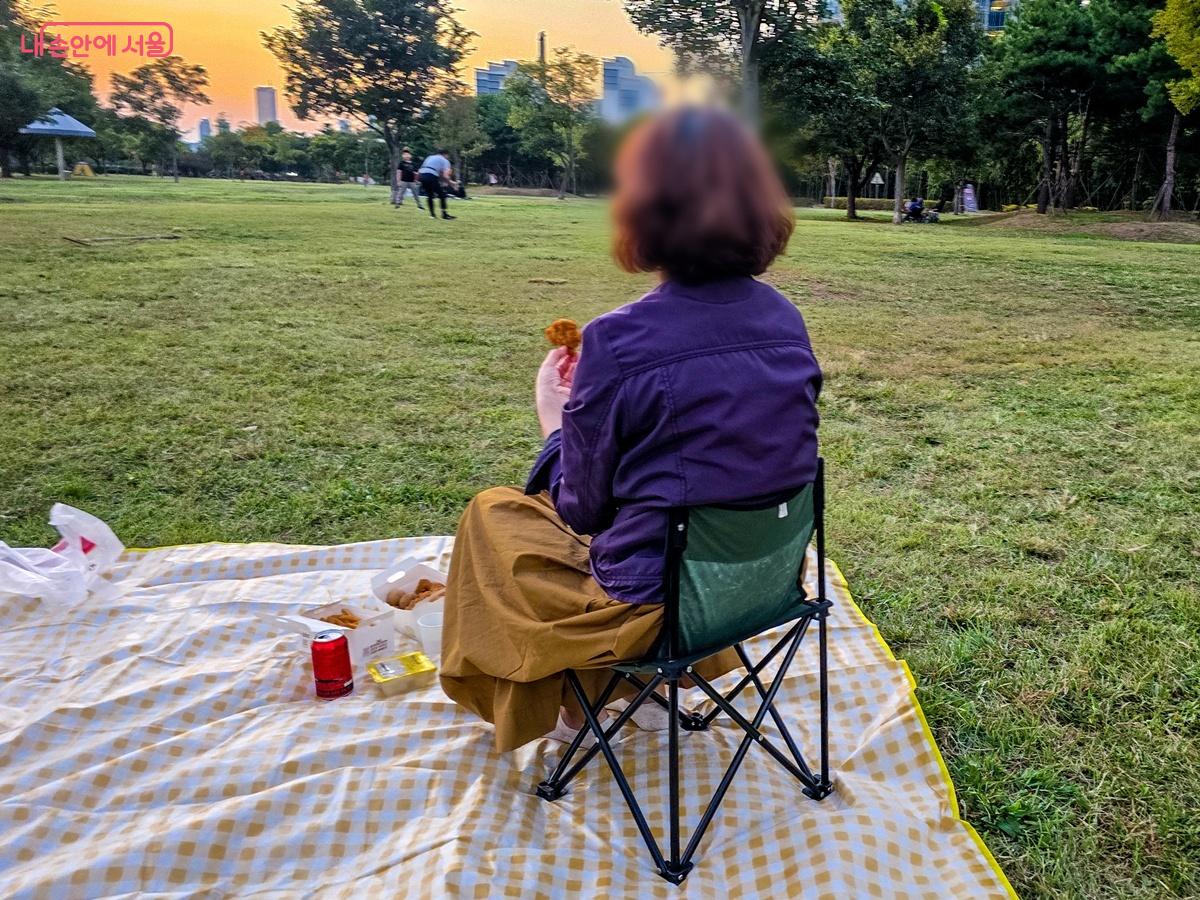 노을 속 잔디밭에서 즐기는 배달 음식 ©양지영