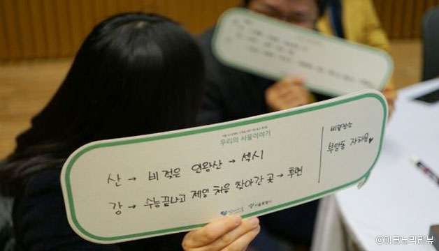 강연에 참여한 시민이 서울에 산과 강에 대해 자신의 생각을 적은 종이를 들고 있다
