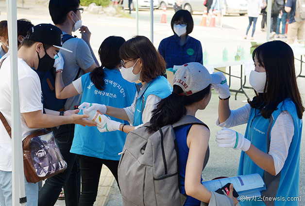 13일 오전 서울 강서구의 한 중학교에서 열린 2015년도 서울시 공무원임용시험 필기시험에 응시한 수험생들이 보건소 직원들에게 발열 체크와 손소독을 받고 있다.ⓒ뉴시스