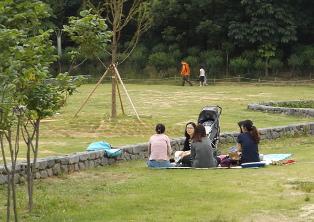 공원 풀밭에 앉아 휴식을 즐기는 시민들