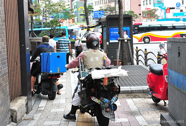 좁은 보도를 지나가는 오토바이들이 시민의 안전을 위협하고 있다 ⓒ뉴시스