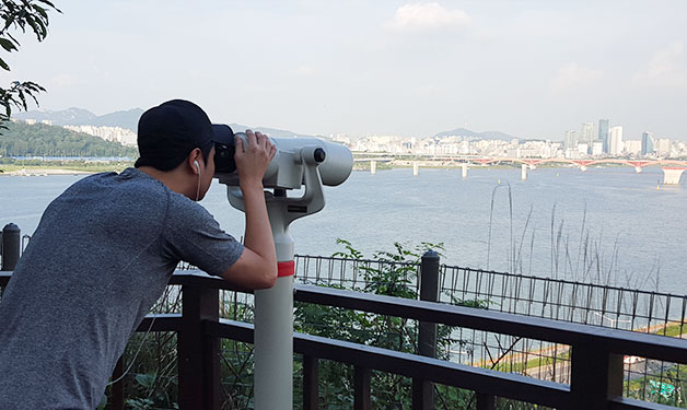 쌍안경으로 남산 서울타워를 보고 있는 인근주민 김도근 씨