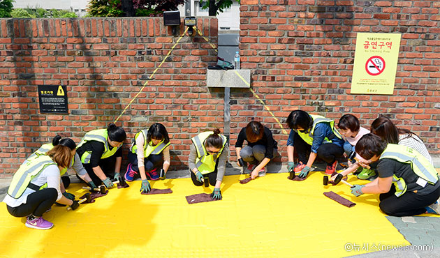 하비에르국제학교 앞 건널목에서 녹색어머니회 회원들이 옐로카펫을 설치하고 있다 ⓒ뉴시스
