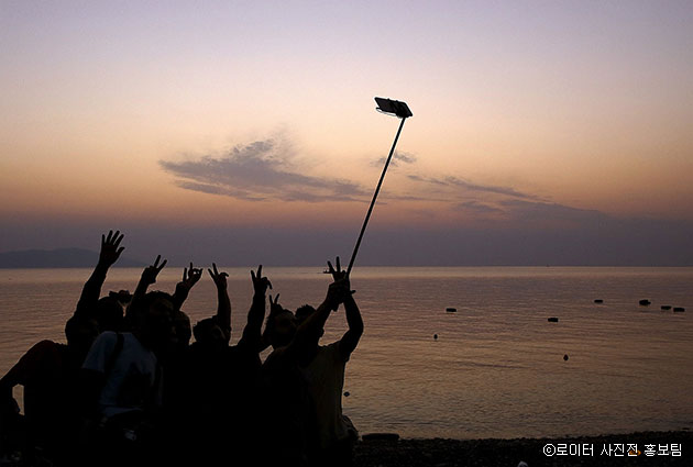 터키에서 에게 해를 건너 그리스 코스 섬 해안에 도착한 직후 시리아 난민들은 자신들이 타고 온 작은 선박 위에서 셀카를 찍으며 평화를 만끽하고 있다. Yannis Behrakis /2015.8.19 ⓒ 로이터 사진전 홍보팀