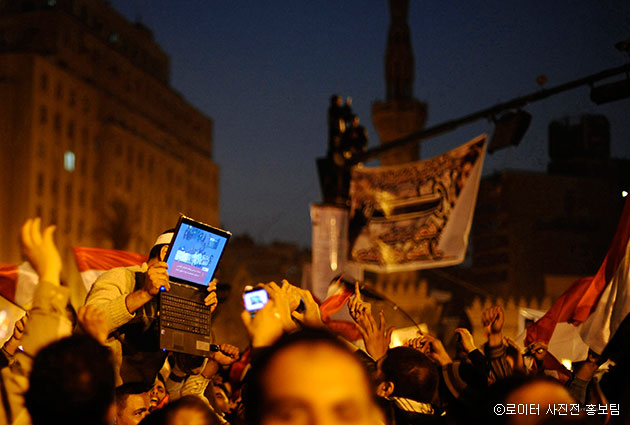 2011년 호시니 무바라크 이집트 대통령의 사임 이후 카이로 타흐리르 광장에서 반정부 지지 자가 노트북을 높이 들어 무바라크의 사임식 장면을 보여주고 있다. Dylan Martinez /2011.02.11 ⓒ 로이터 사진전 홍보팀