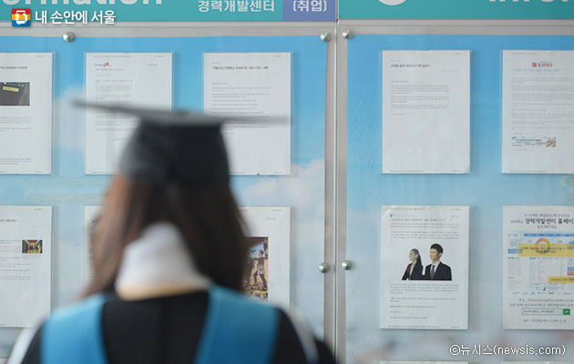 한 대학교에서 학사모를 쓴 졸업생이 취업 게시판을 보고 있다.ⓒ뉴시스
