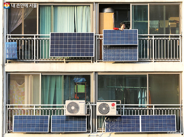 서울 노원구의 한 아파트 단지에서 한 입주민이 베란다에 설치된 태양광 판넬을 살펴보고 있다.ⓒnews1