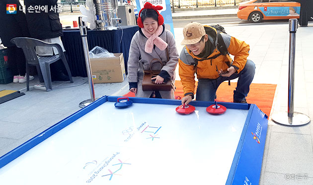 한국관광공사 서울센터 앞, 컬링 체험 이벤트에 참여 중인 중국인 커플ⓒ최은주