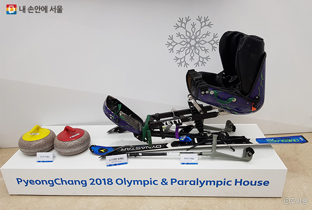 을지로 하나은행본점 로비에 전시된 올림픽기념 전시부스. 장애인 스키복과 장비가 전시되어 있다.