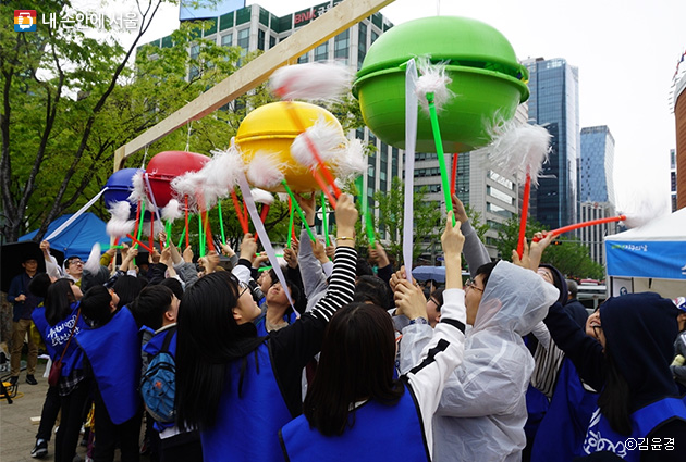 서울광장에서 열린 '지구의 날' 기념식에서 에너지수호천사단 학생들이 모여 박을 털고 있다.