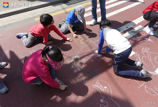 분필로 거리 바닥에 그림을 맘껏 그리고 있는 아이들