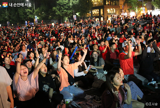 광화문광장에 모인 축구팬들이 대한민국을 외치며 열렬하게 응원하고 있다