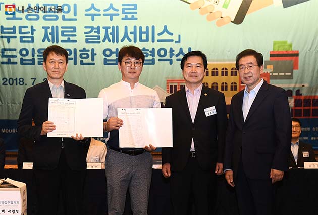 소상공인들이 홍종학 중소벤처기업부 장관과 박원순 서울시장에게 카드수수료 인하 서명부를 전달했다
