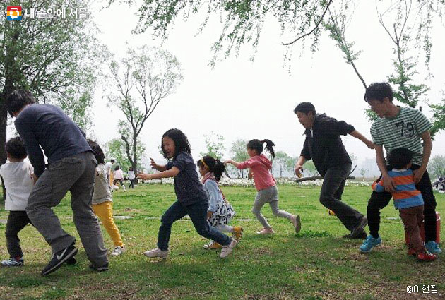 공동육아 어린이집 학부모와 아이들이 함께 뛰어놀고 있다