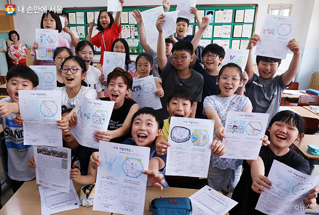 여름방학을 맞은 초등학생들이 방학계획표를 흔들며 웃고 있다