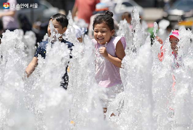 폭염특보가 발효되는 등 무더운 날씨가 이어지자 어린이들이 분수대에서 물놀이를 하고 있다.