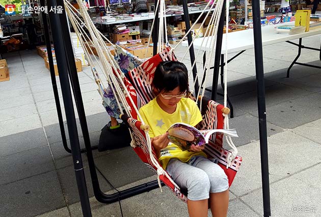 의자에 앉아 책을 읽는 어린이
