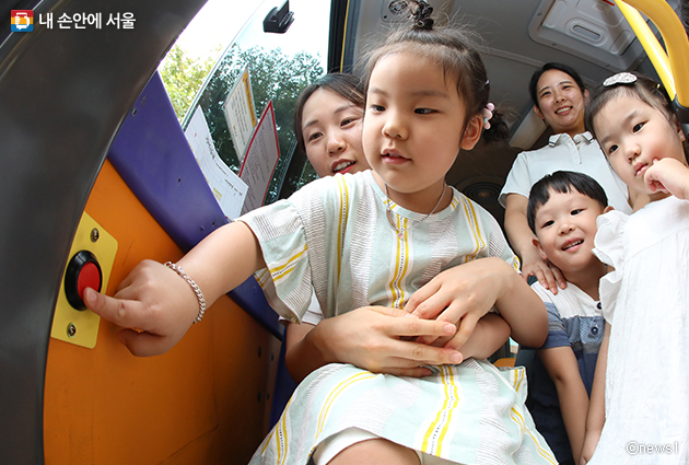 아이들이 어린이집 차량에 설치된 ‘잠자는 아이 확인장치’ 사용법을 들으며 버튼을 눌러보고 있다.
