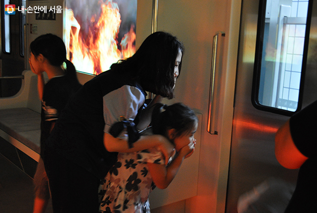 지하철 화재안전체험장에서 화재상황을 가정하여 대피하고 있는 아이와 어른