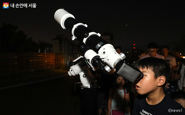 지난 8월 서울시립과학관에서 열린 '화성-지구 대접근 관측회'에서 한 어린이가 목성을 관측하고 있다
