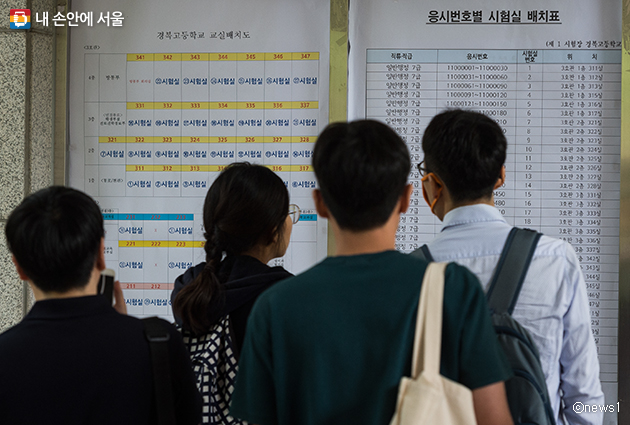 서울시 공무원 임용 시험 응시생들이 시험실 배치표를 살펴보고 있다