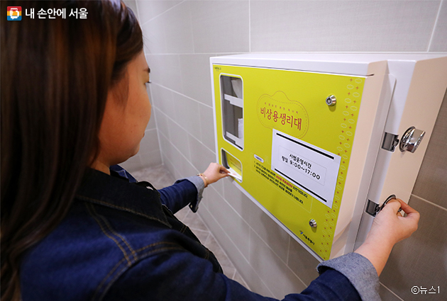 한 시민이 비상용생리대 자판기를 이용하고 있다.