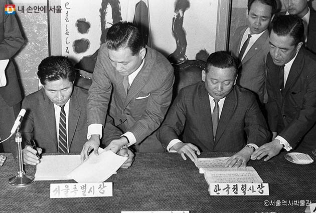 김현옥 서울시장과 박영준 한국전력 사장이 전차사업 양도협정서에 서명하는 모습