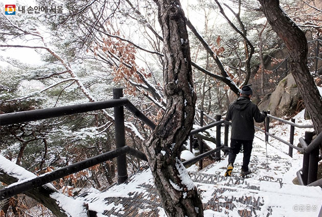 운치 있는 겨울 산속을 걷는 시민들