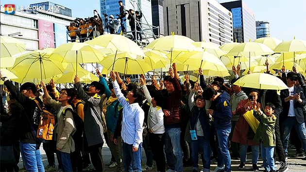 4시 16분이 되자 일제히 우산을 펼쳐 세월호의 상징인 노란 리본 만들기 플랩시몹이 진행됐다