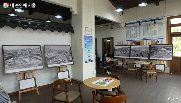 신촌의 과거 모습을 담은 흑백사진들과 기차역 시간표가 전시된 옛 신촌역 내부