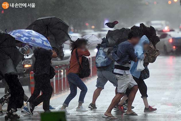 태풍에 맞서 힘겹게 걸어가는 사람들