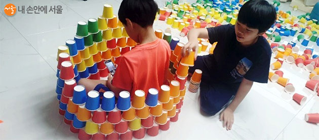 색색깔 종이컵 쌓기 놀이를 하며 아이들이 즐거운 시간을 보내고 있다