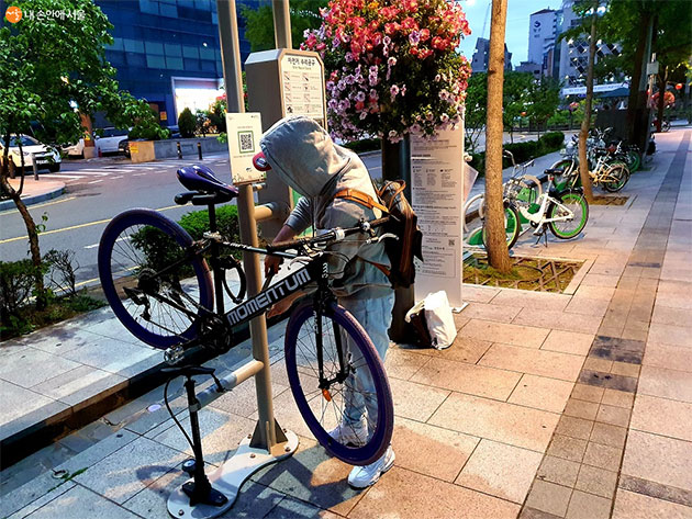 한 시민이 수리대에서 스스로 자전거를 고치고 있다