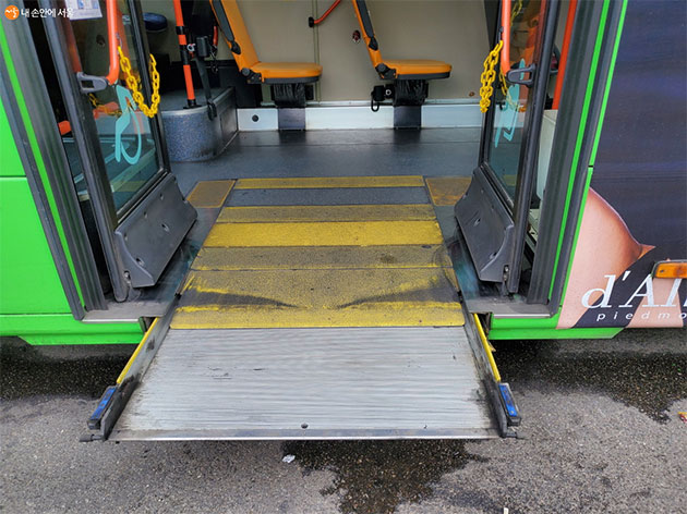 장애인을 위한 저상버스 슬라이딩 리프트가 작동되어 펼쳐지고 있다. 