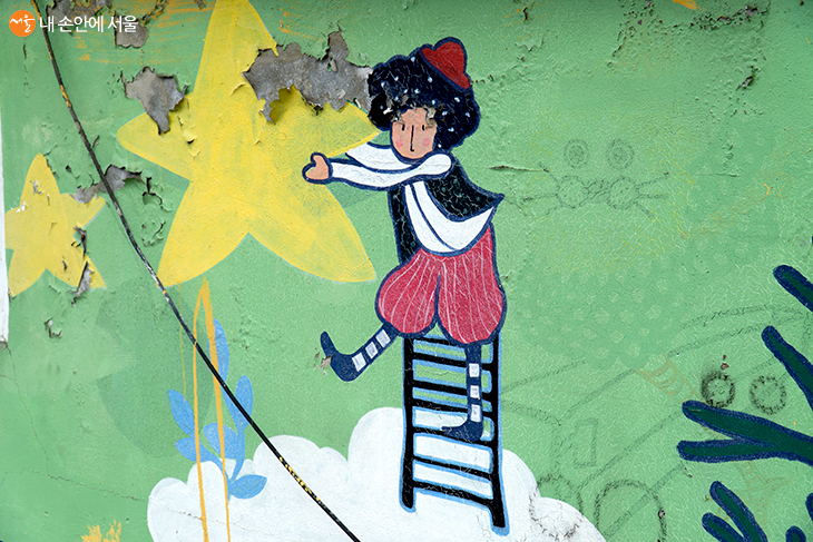 마을에 있는 벽화 중 하나인 이 그림은 별을 따는 소년의 모습을 잘 표현하고 있다 ©강동호