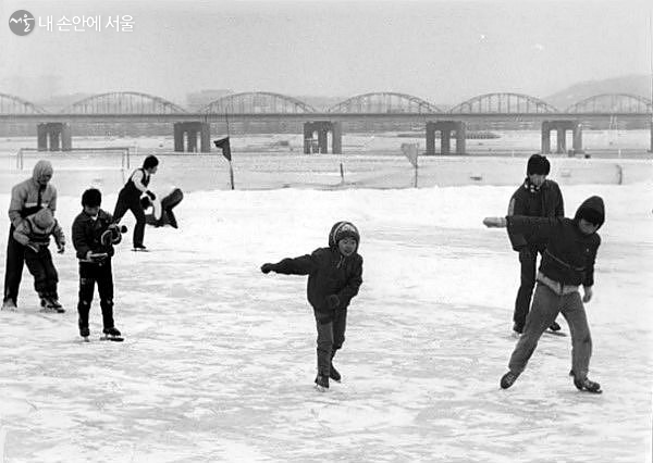 1960년대 노들섬 근처에서 스케이트를 타는 아이들의 옛 흑백사진. 뒤에는 한강대교가 보인다