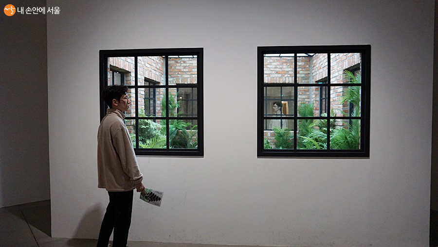 거울과 유리를 다양하게 활용한 레안드로 에를리치 작품을 감상하고 있는 관람객의 모습