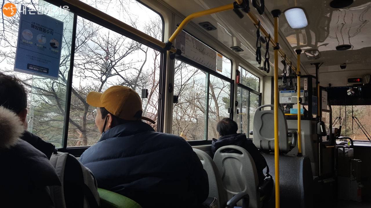 녹색순환버스를 타고 도심풍경을 구경하는 승객들
