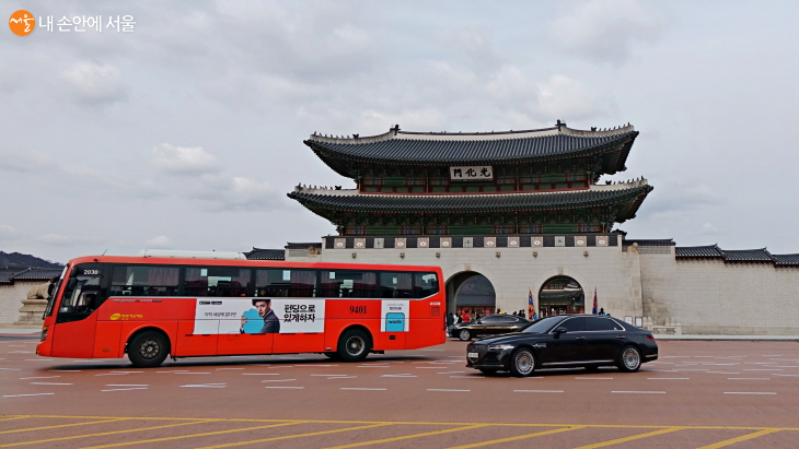 빨간색 광역버스가 광화문을 지나고 있다. 
