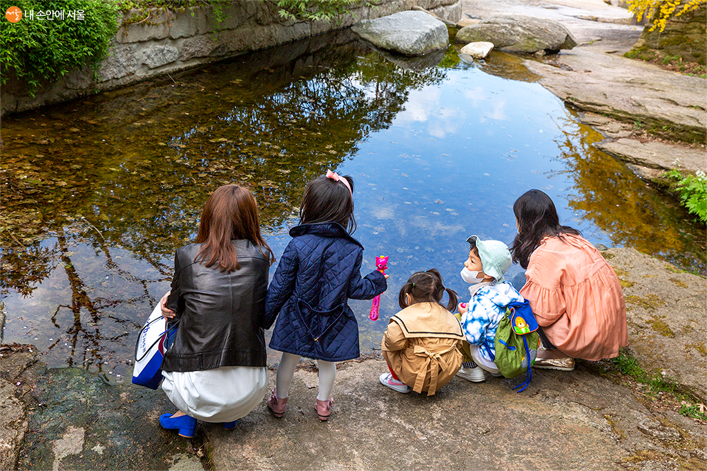 봄나들이를 나온 아이들이 물가에서 즐거운 시간을 보내고 있다 