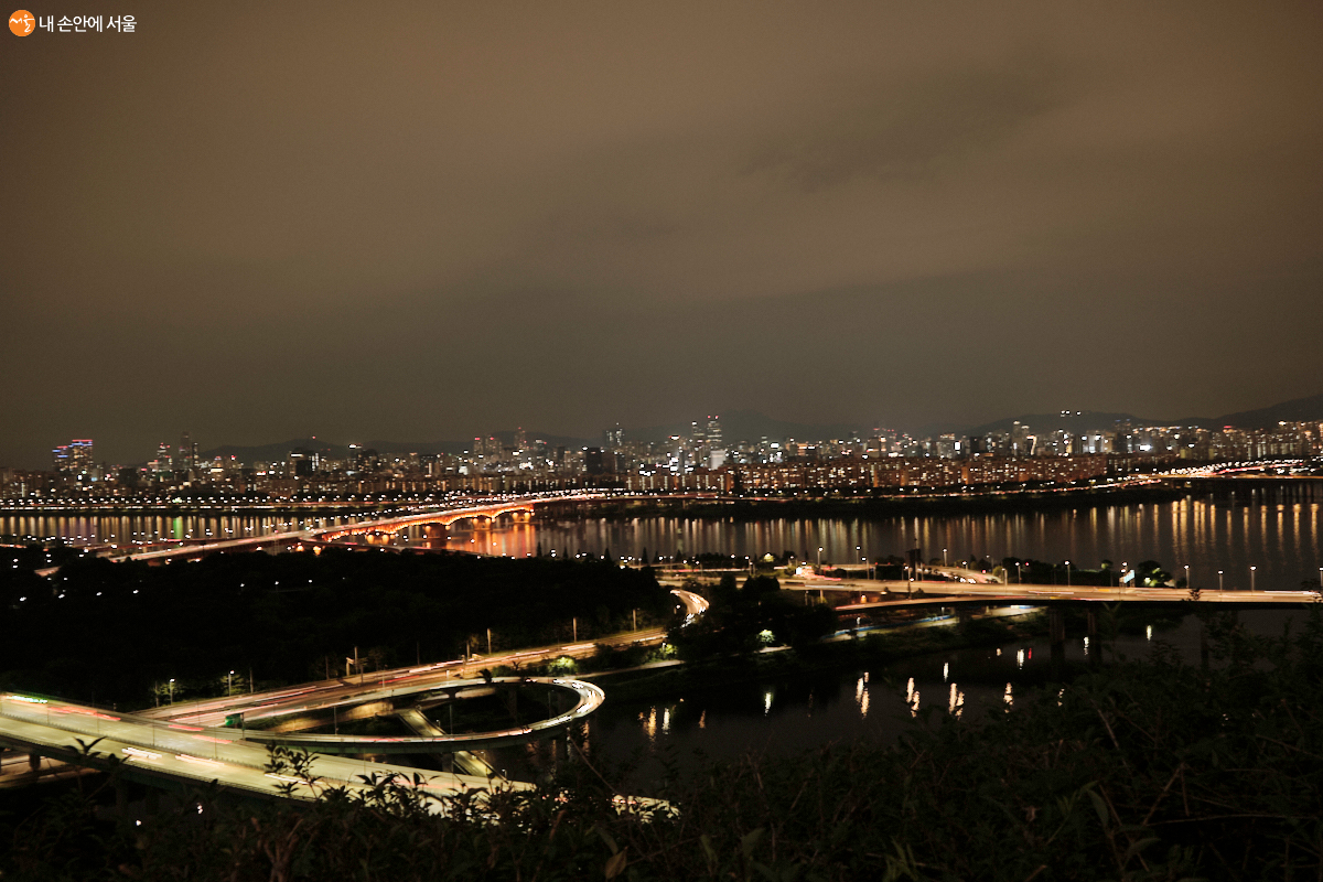 강변북로와 동부 간선도로가 만나는 도로에 자동차들이 빠른 속도로 달리며 빛을 내뿜는다