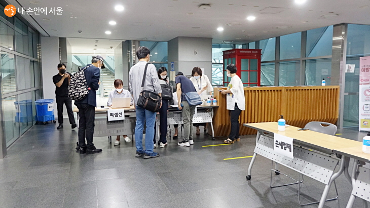 서울시민회의 5차 주제별회의 참석자들이 열 체크를 하고 명단을 확인하고 있다. 
