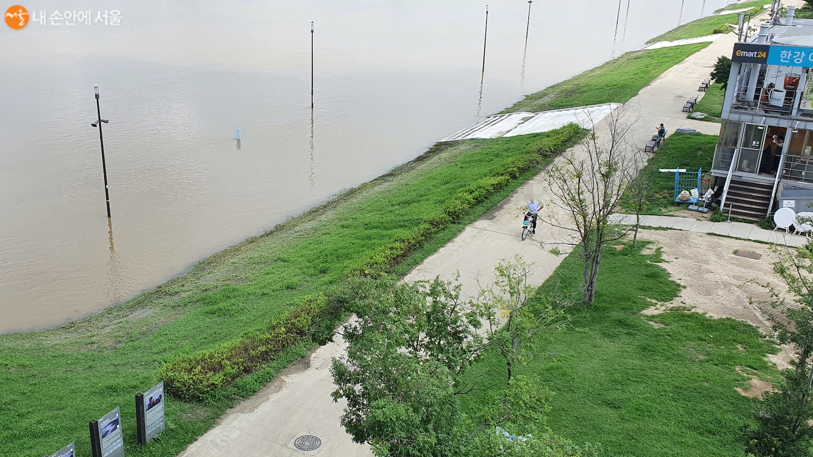 불어난 한강물 옆에서 자전거를 타고 있는 시민이 위험해 보인다.