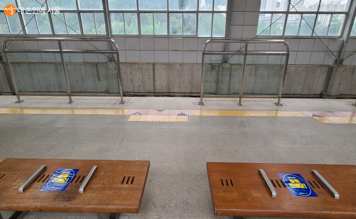 전철 승강장 의자 가운데에 '비워주세요'란 문구가 부착되어 있다.