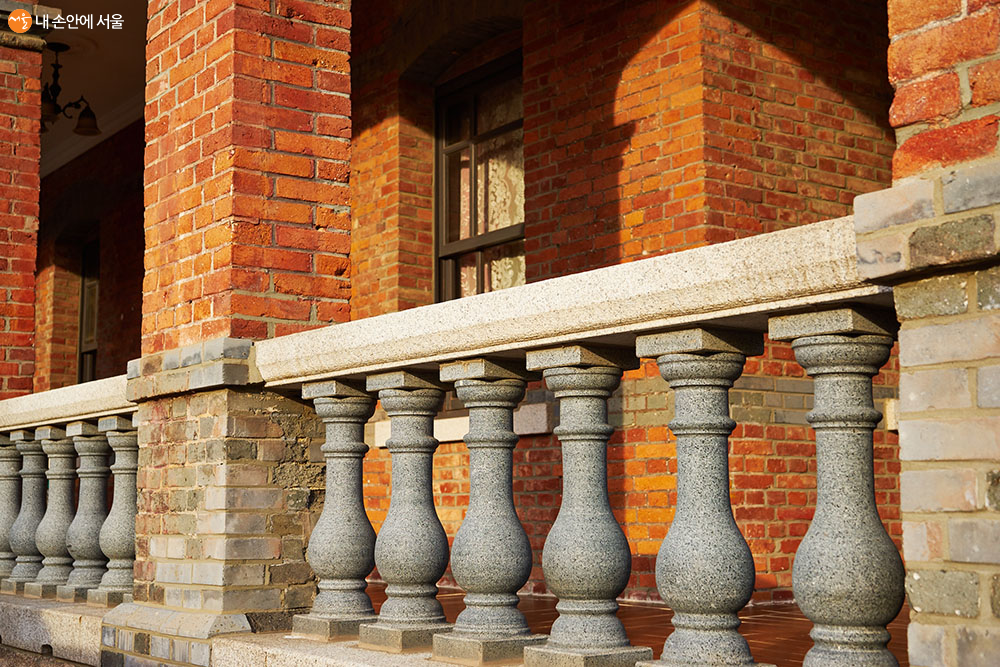 회랑의 난간 장식과 붉은 벽돌, 오후의 그림자가 만드는 낯선 풍경이 방문객의 마음을 끈다